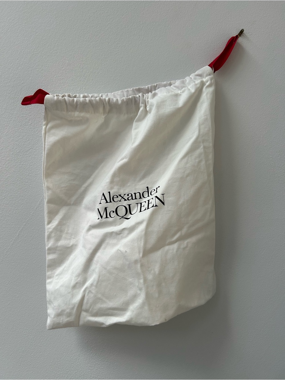 White dust bag with Alexander McQueen logo on both sides